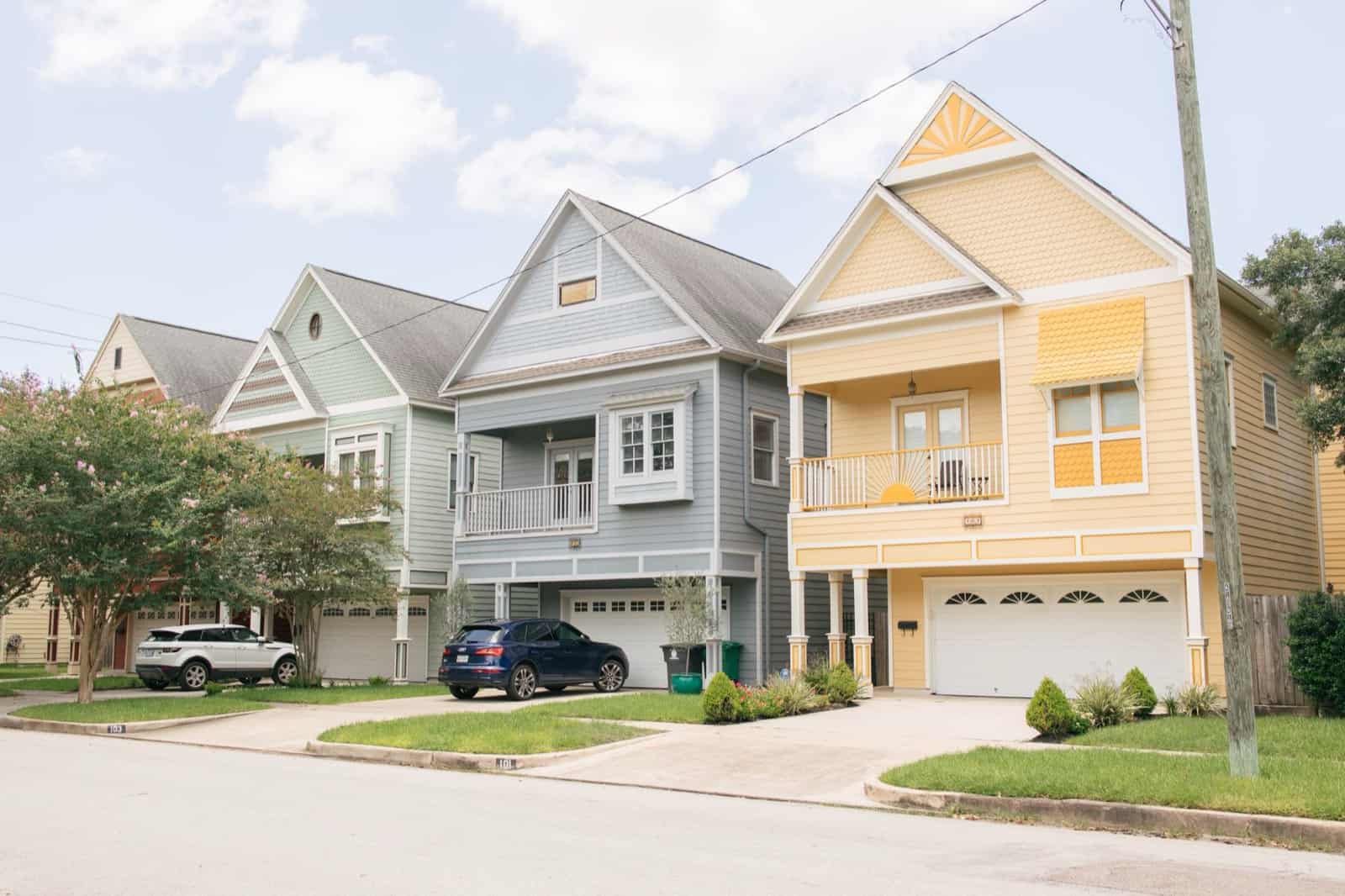 A row of colorful two-story homes on a Texas residential street