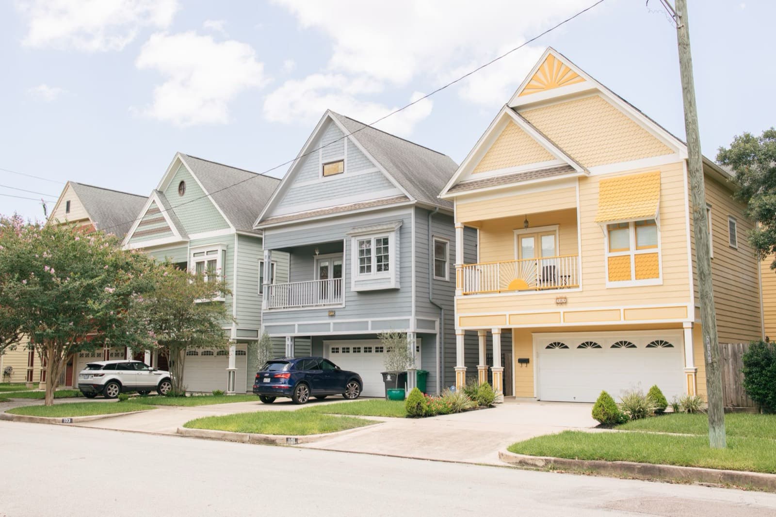 A row of colorful two-story homes on a Texas residential street