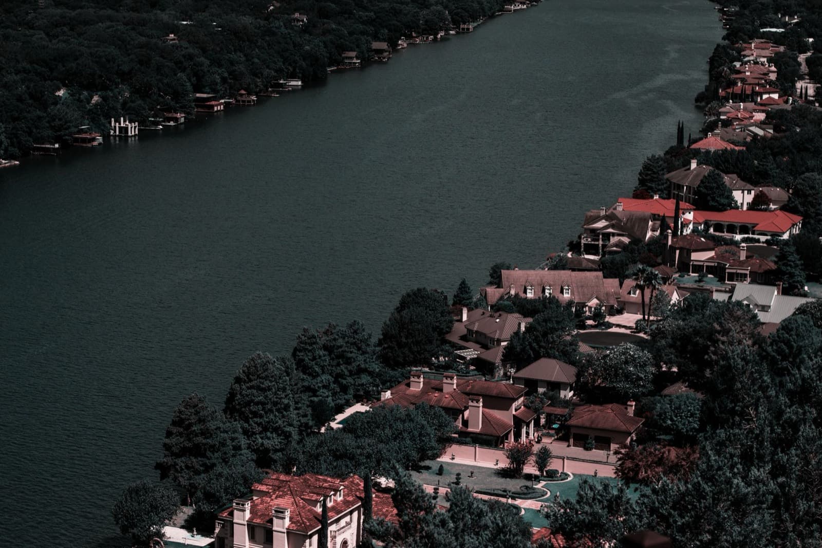 Aerial view of upscale homes overlooking the water at dusk