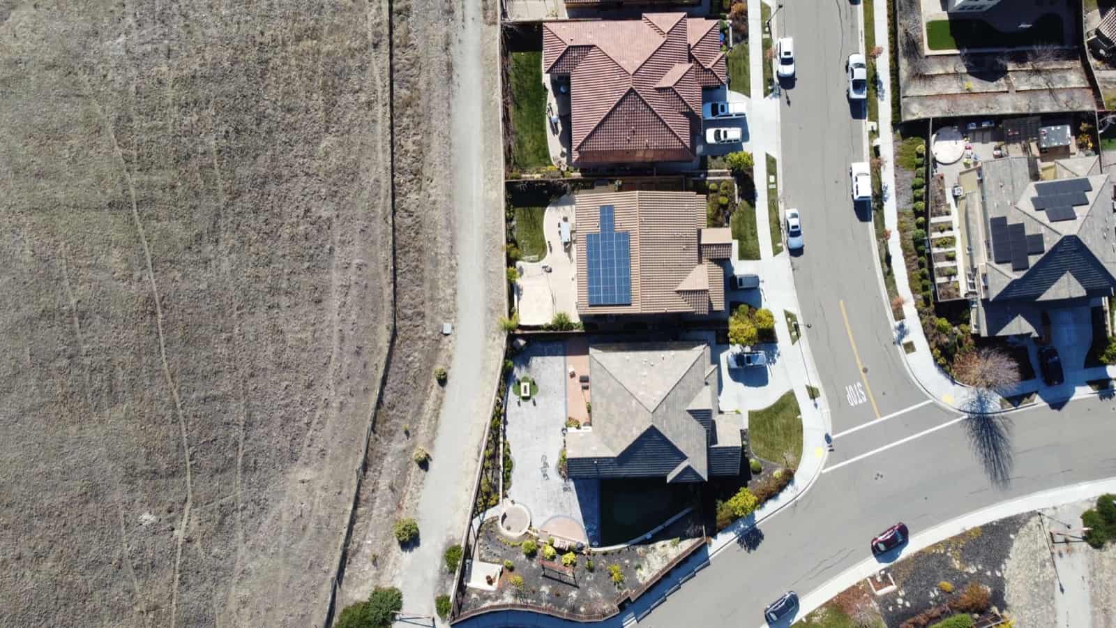 Aerial view of homes at the edge of open Texas ranchland