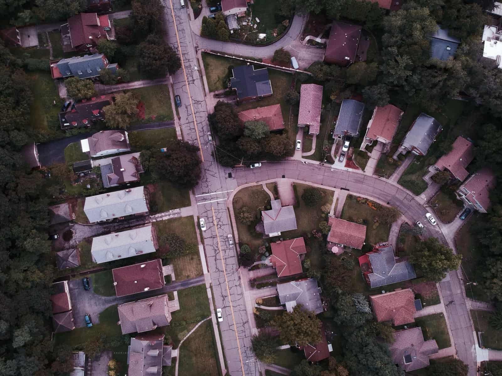 Aerial view of a small residential neighborhood among green trees