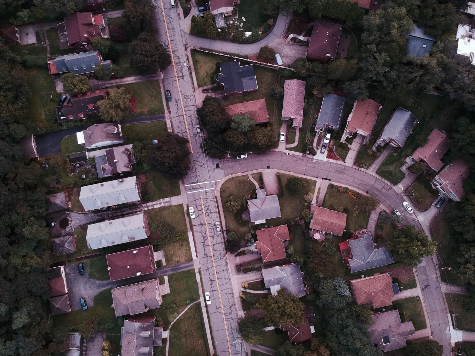 Aerial view of a small residential neighborhood among green trees