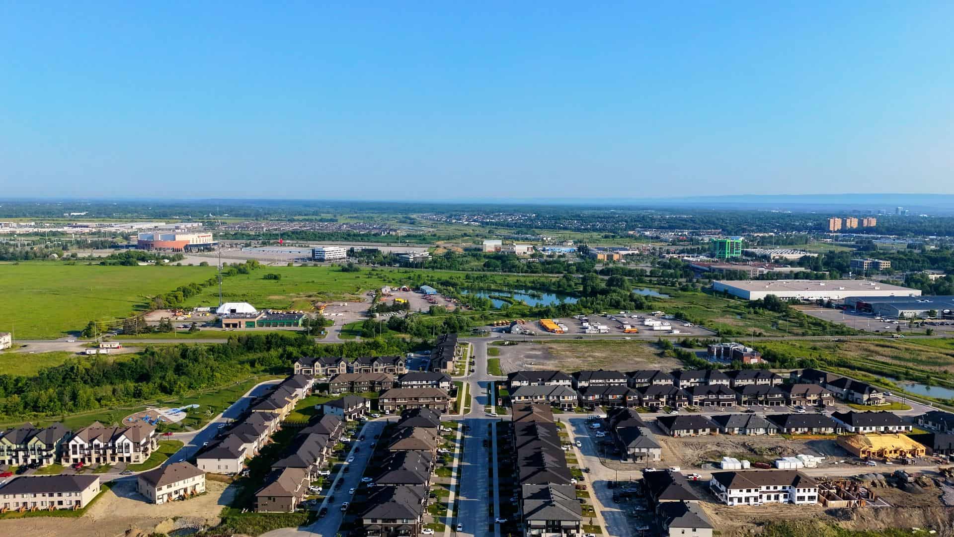 Aerial view of a newly built residential development on flat ground at the edge of a growing town