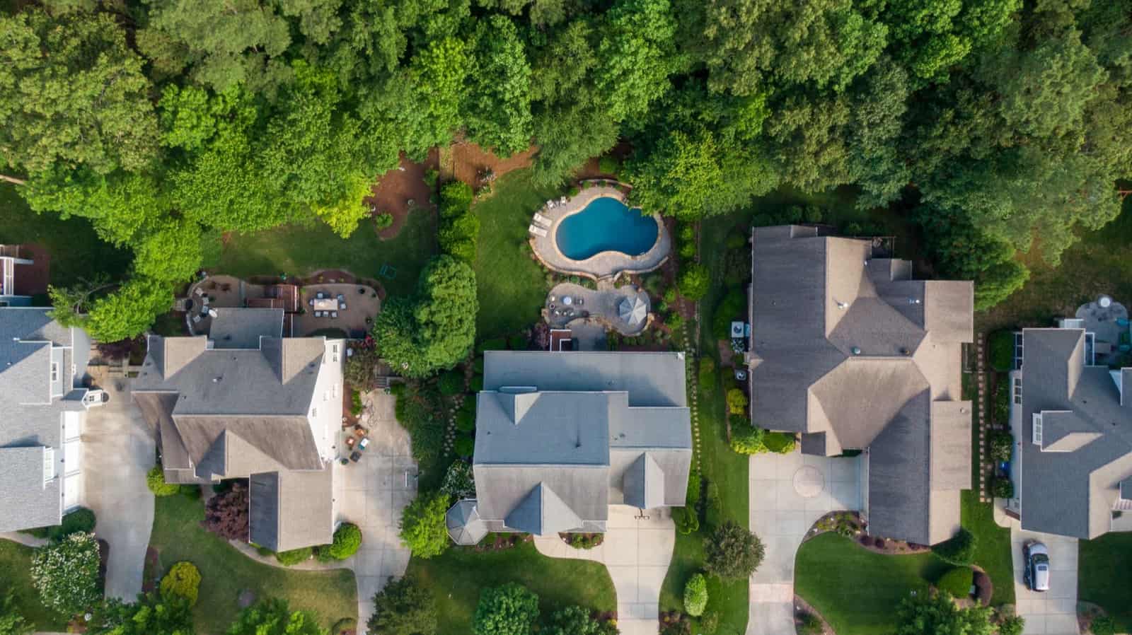 Aerial view of upscale homes with pools set among mature trees