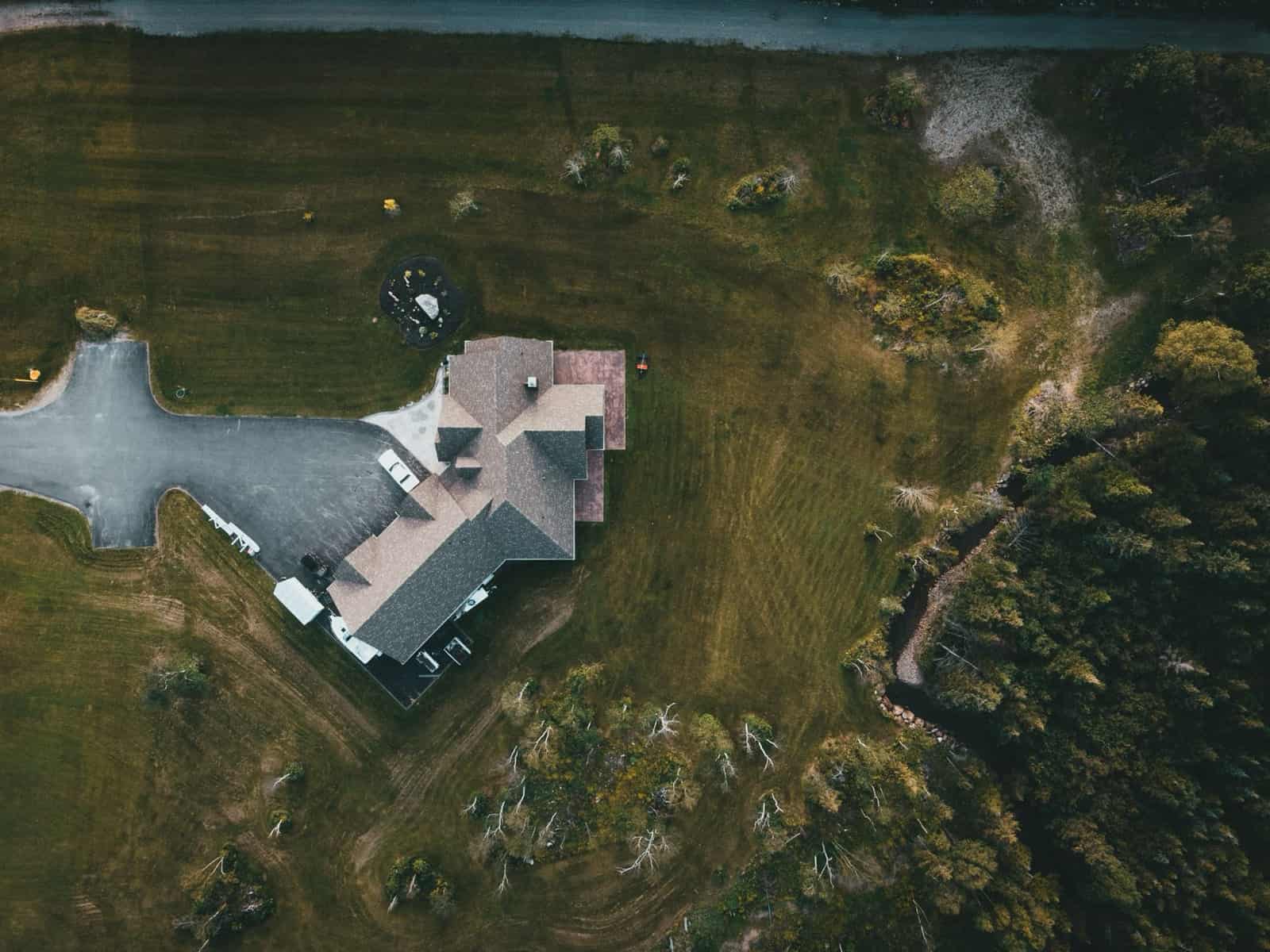 Aerial view of a large home on an acreage lot beside open land