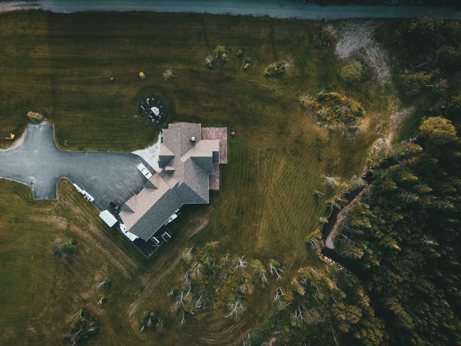 Aerial view of a large home on an acreage lot beside open land