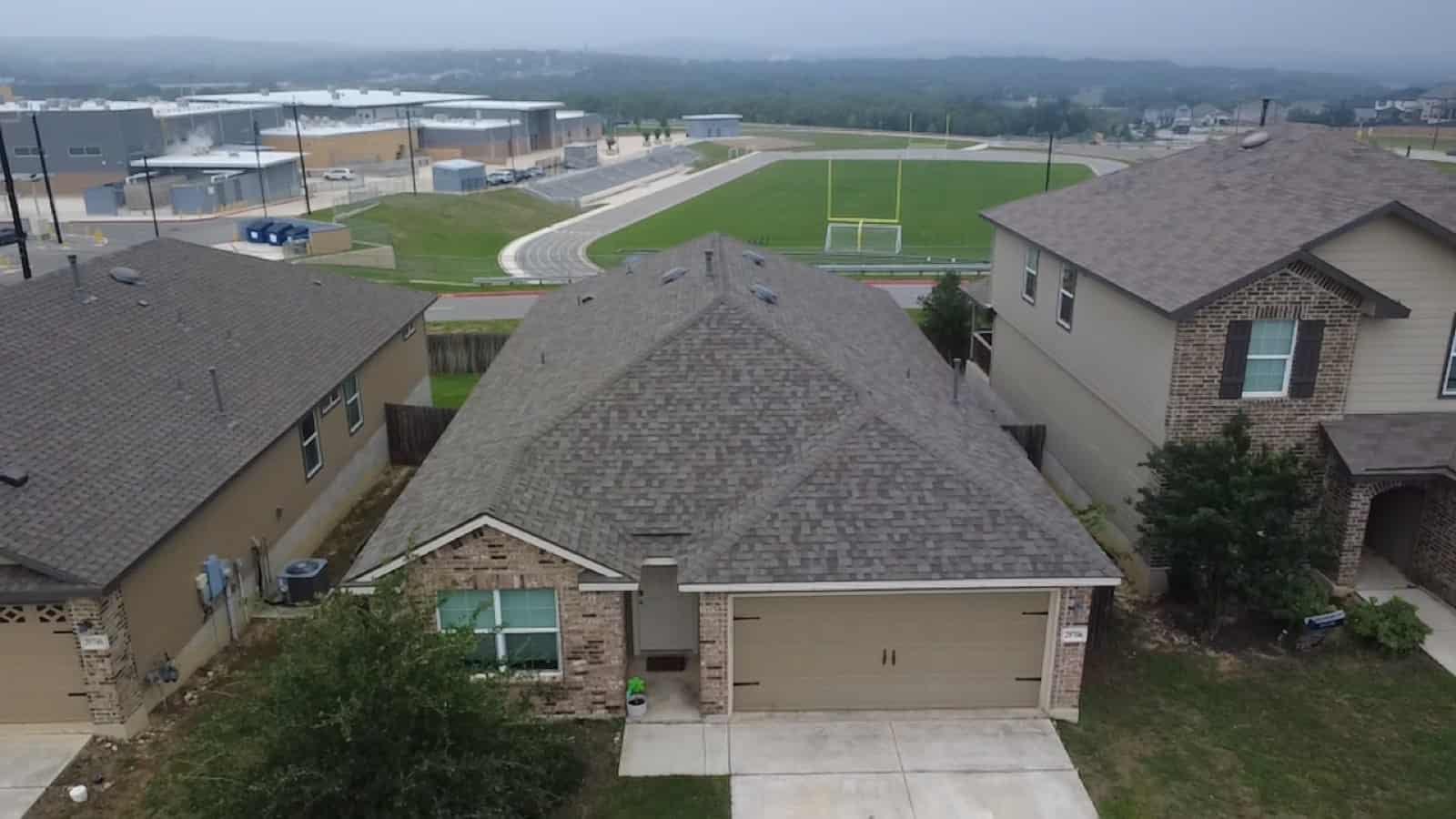 Aerial view of a San Antonio neighborhood with a freshly roofed home in the foreground