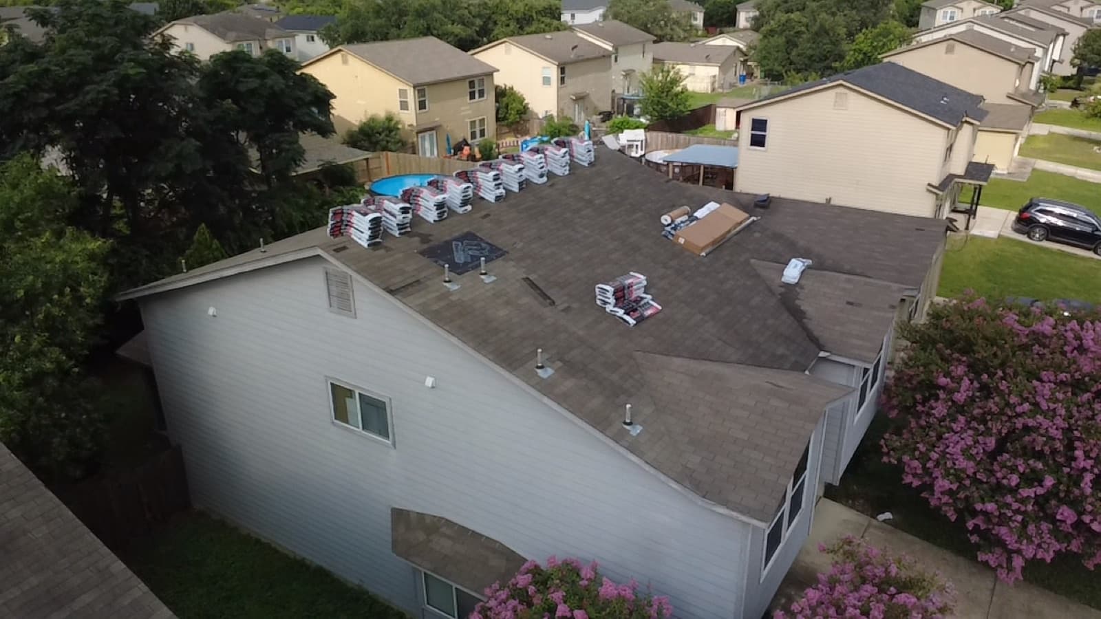 Low-slope roof replacement on a white single-story home