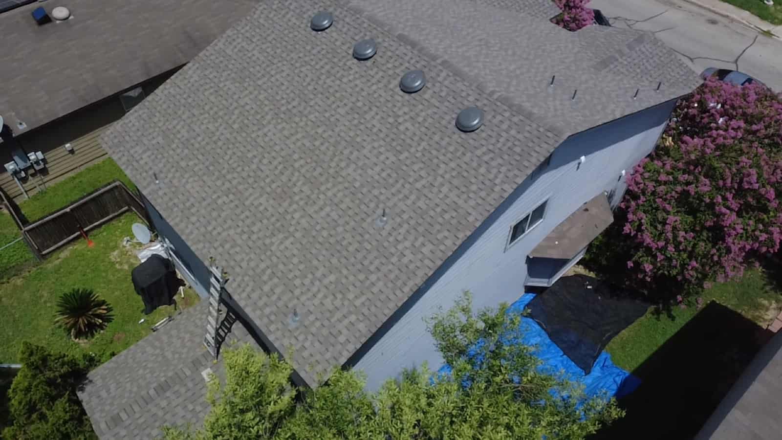 Dark architectural shingle roof with rooftop solar, aerial view