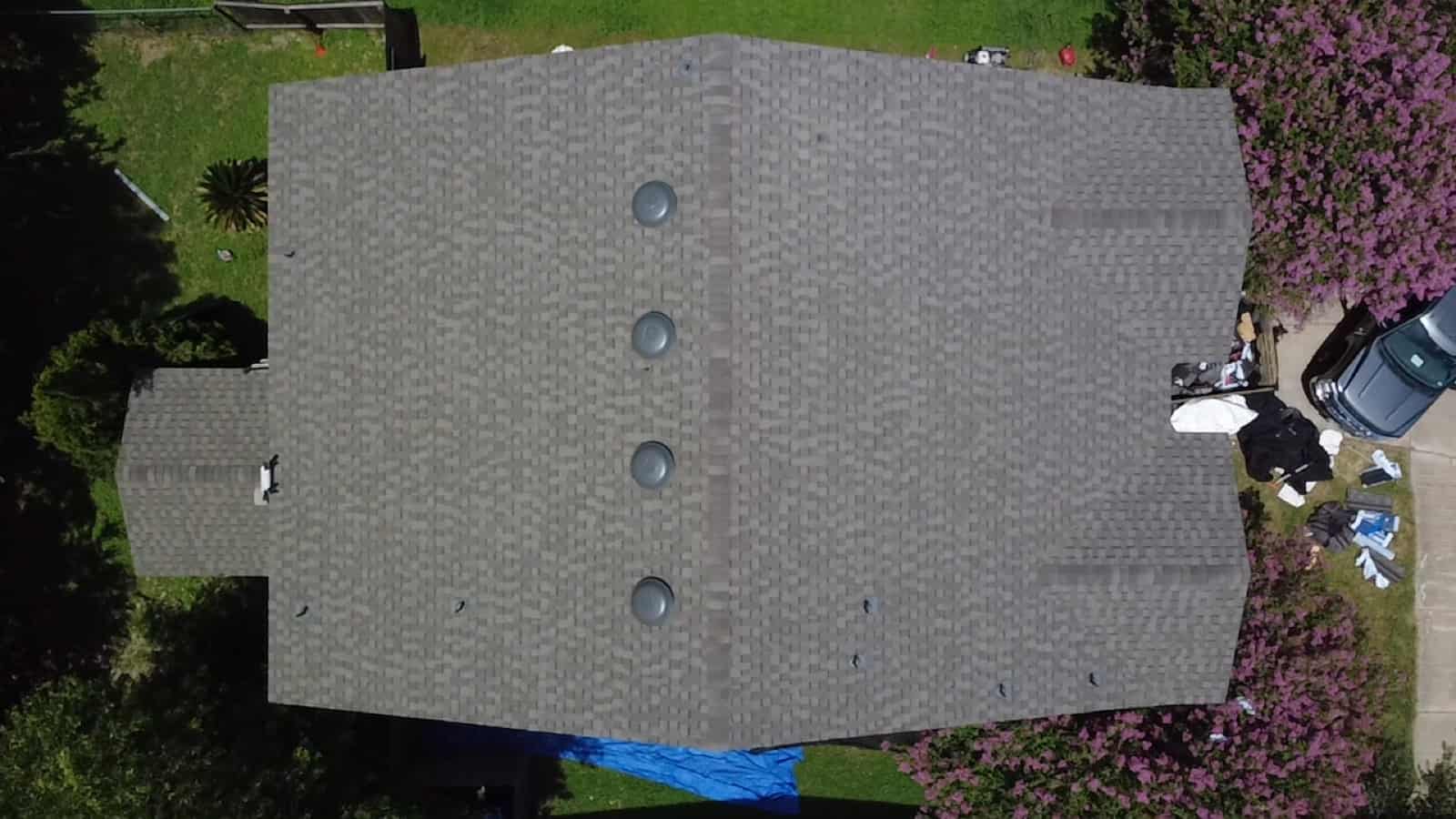 Close aerial of vent pipes and flashing on a shingle roof, common points where leaks start