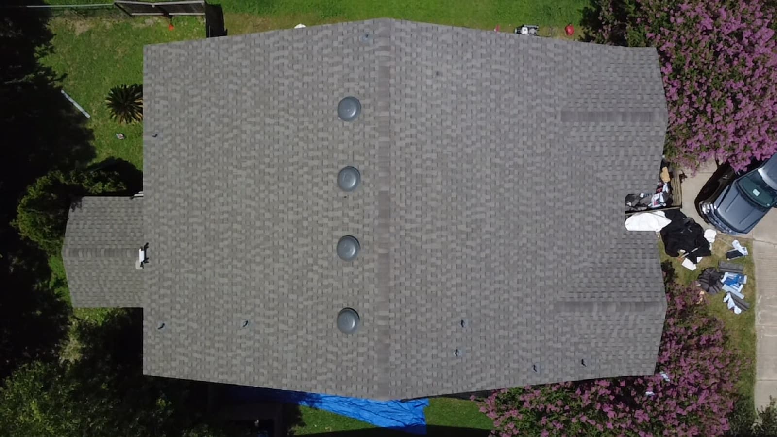 Close aerial of vent pipes and flashing on a shingle roof, common points where leaks start
